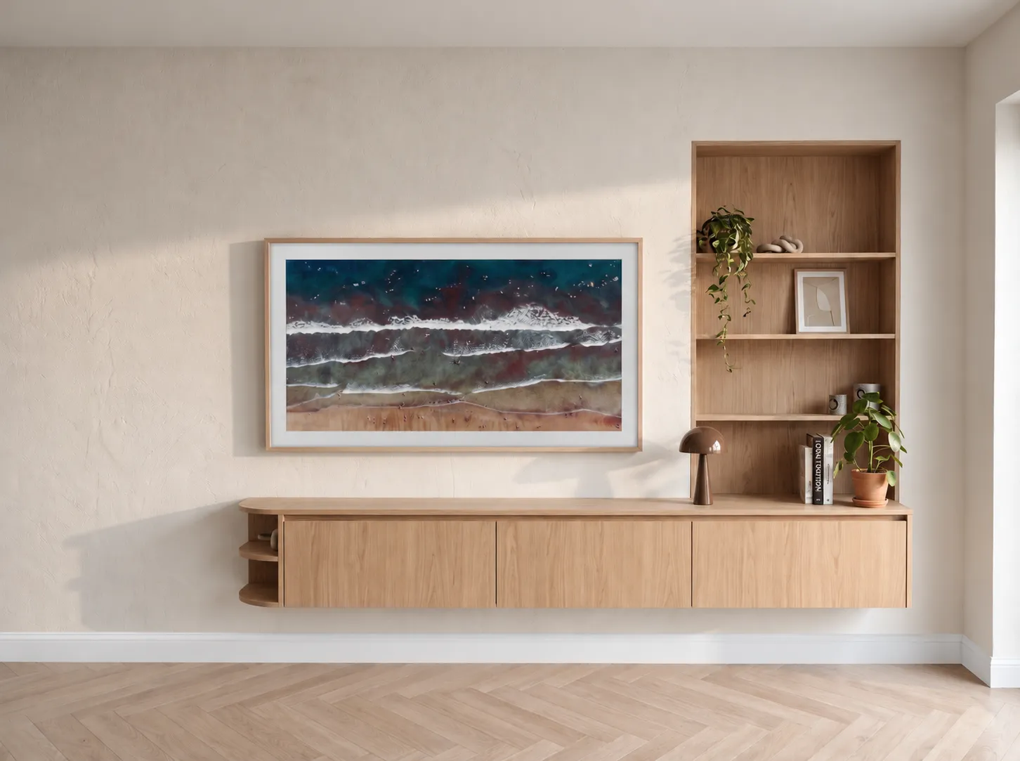 Meuble bas et bibliothèque sur mesure en chêne clair sous un tableau encadré, mur à l’enduit blanc cassé